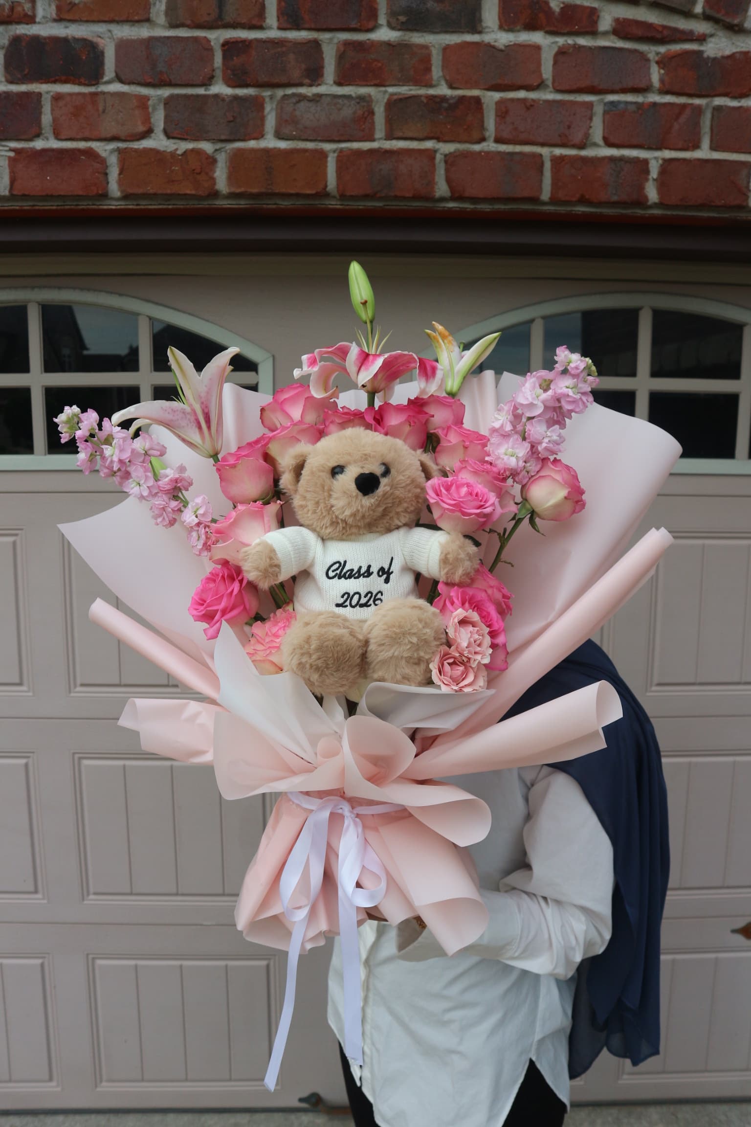 Graduation plushie bouquet with teddy bear in Class of 2026 sweater among pink roses, lilies and stock